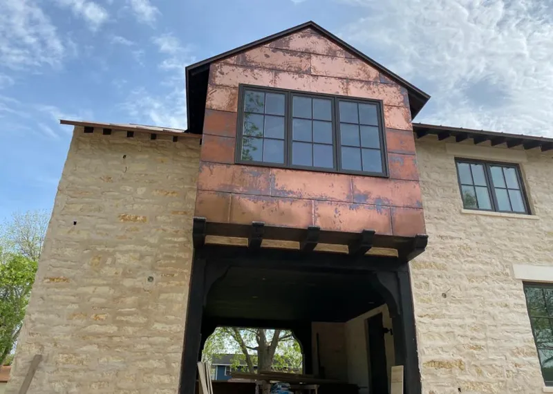 Copper metal panel facade on a stone building for Skylight Installation in Gypsum